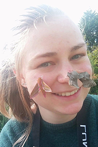 ECORSIC PhD student, Laura Penny, with two moths on their face.